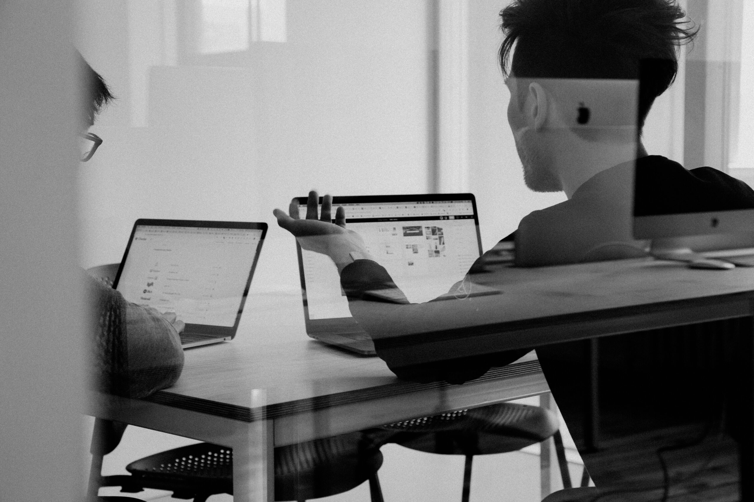 Two people collaborating at laptops